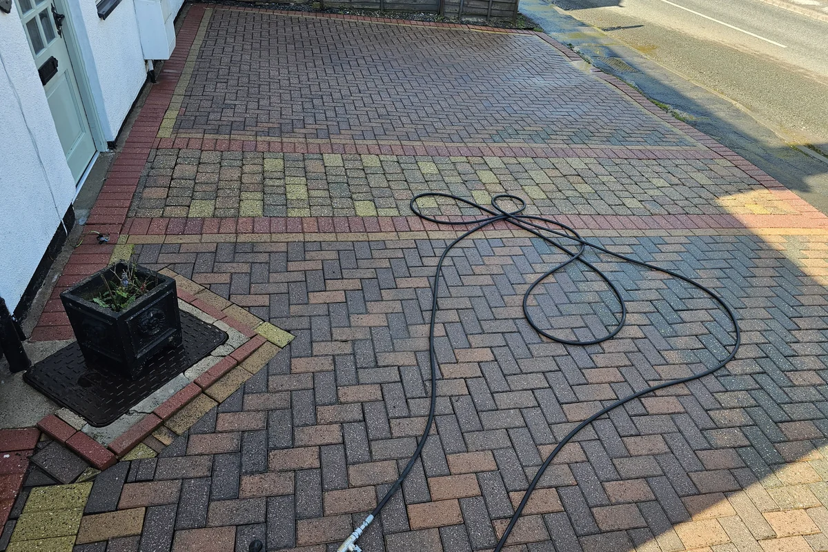 Pressure washing in progress on exterior paving by Exact Clean