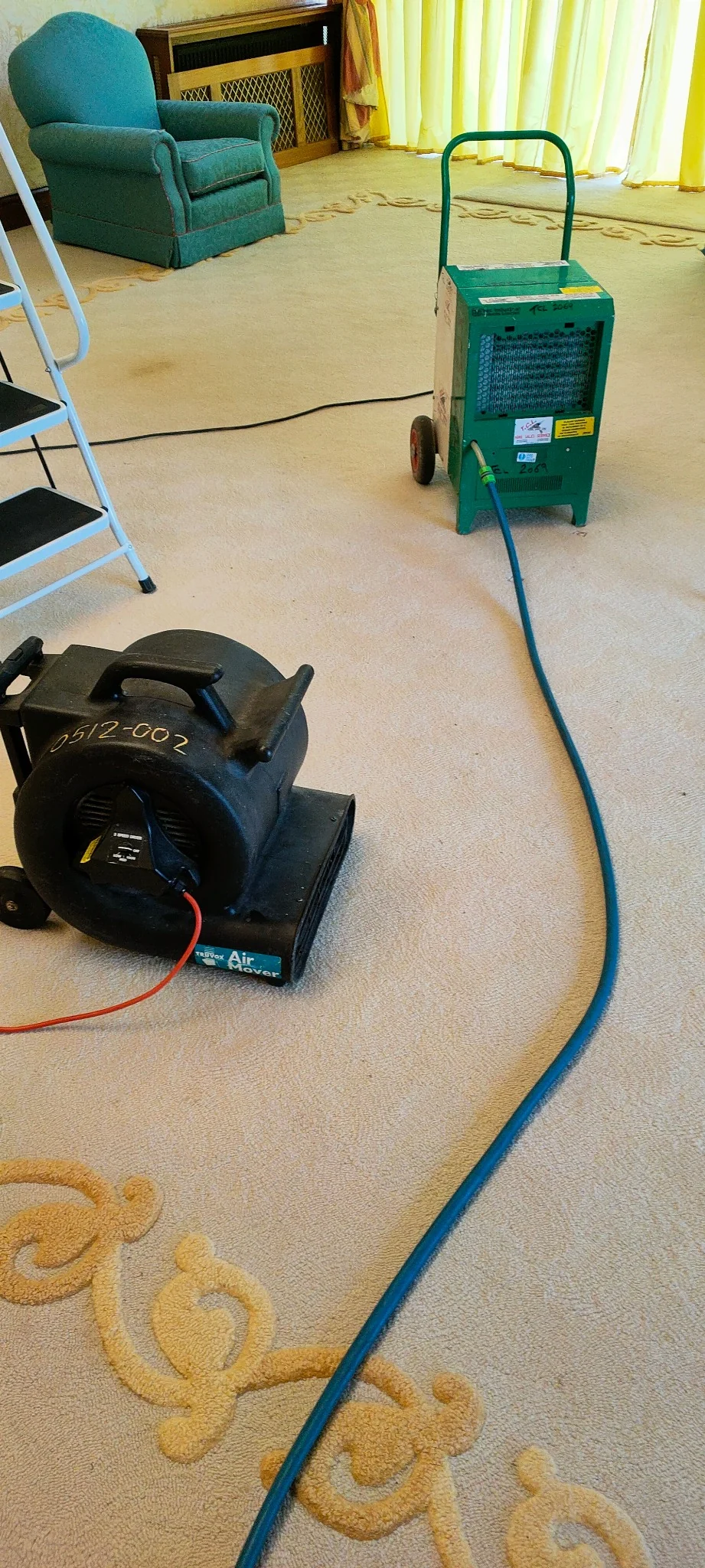 Dehumidifier and air mover being used to dry a flood affected room