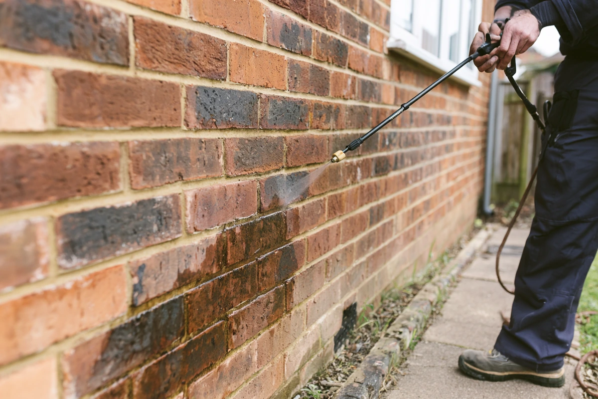 Professional water repellent treatment being applied to an exterior brick wall by Exact Clean